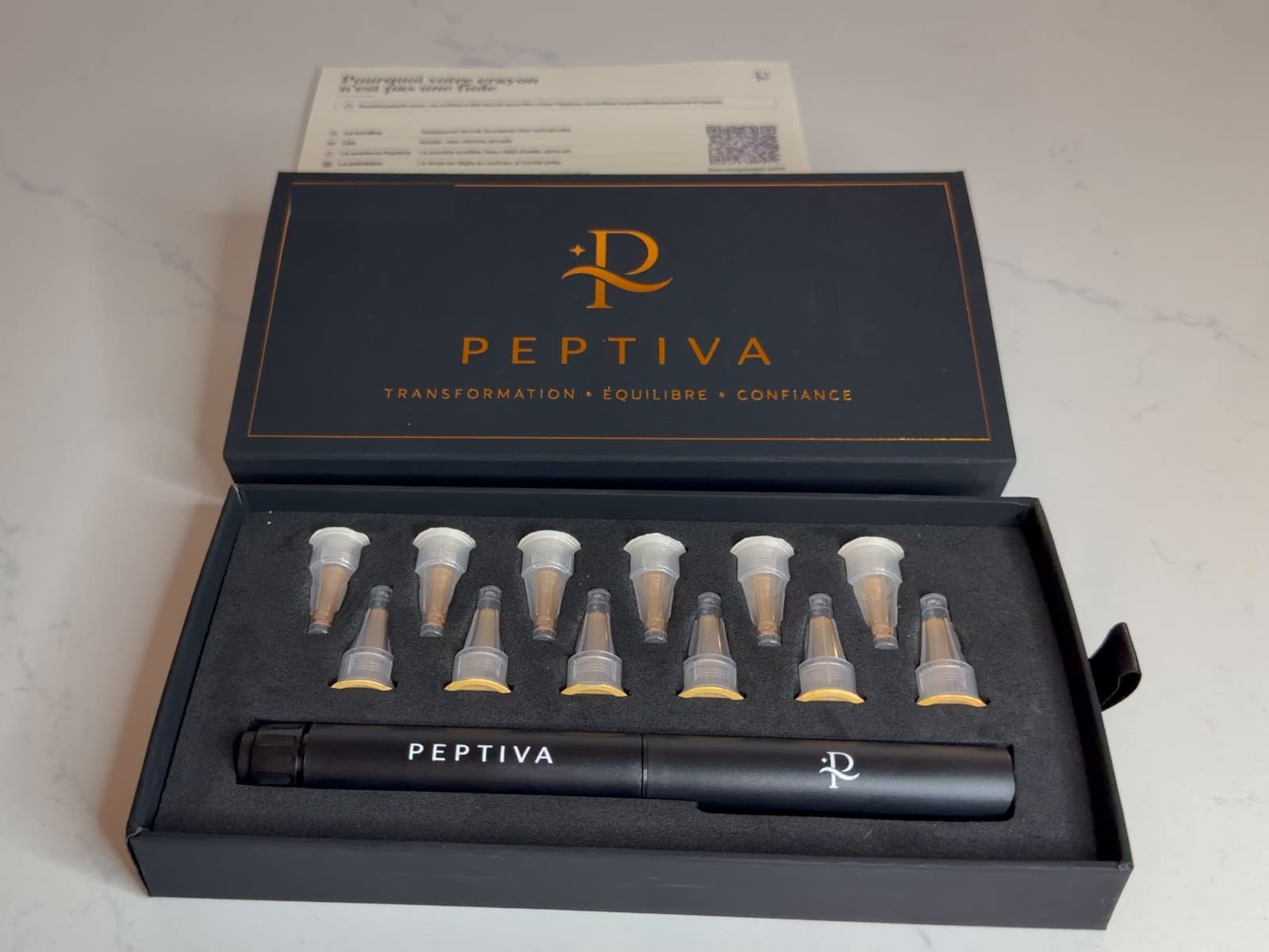 Le coffret Peptiva ouvert : le stylo, ses douze embouts et sa carte.